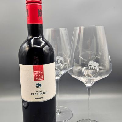eine Flasche Wein neben zwei Weingläsern