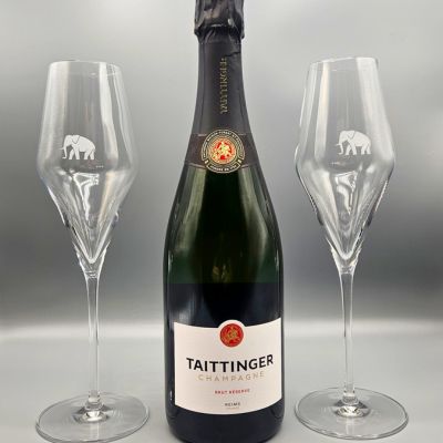 eine Flasche Champagner neben zwei leeren Weingläsern