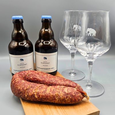 zwei Flaschen Wein neben einem Tisch mit Würstchen